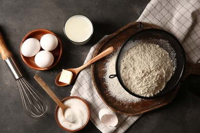 Photo of Different ingredients for dough on grey textured table, flat lay