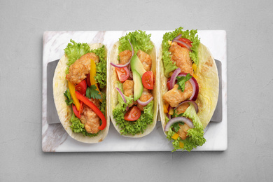 Photo of Delicious fish tacos served on grey table, top view