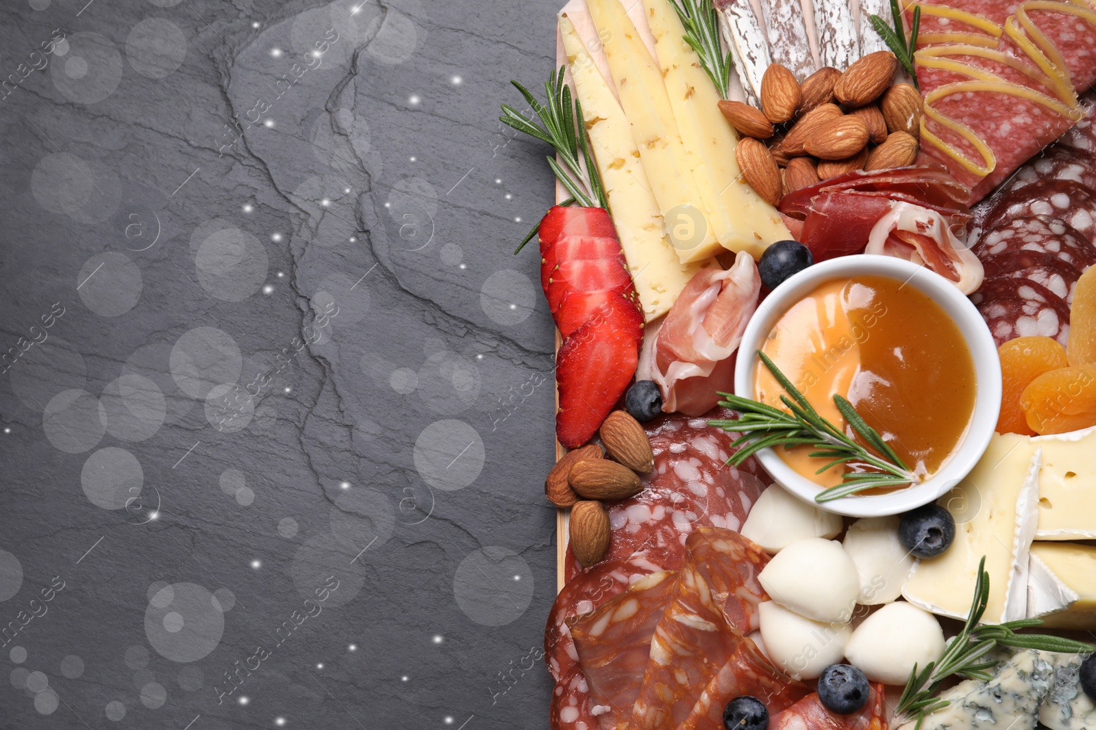 Photo of Different delicious snacks on black table, top view. Space for text