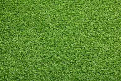 Photo of Green artificial grass as background, top view