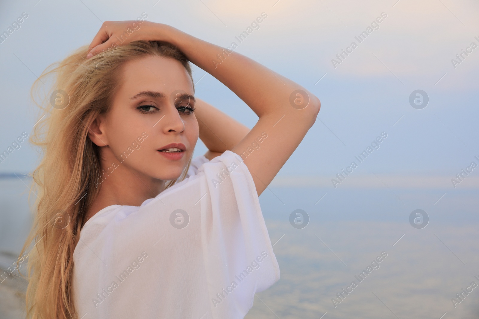 Photo of Beautiful young woman near sea, space for text