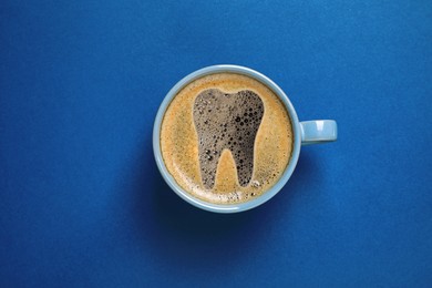 Image of Coffee causing dental problem. Cup of hot drink on blue background, top view