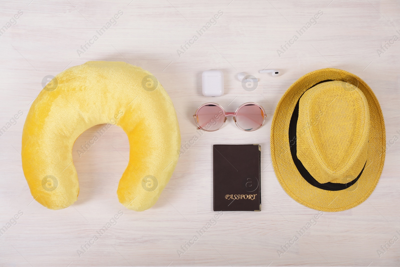 Photo of Flat lay composition with yellow travel pillow on white wooden background