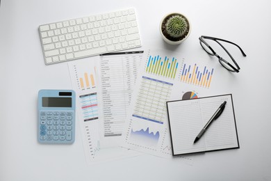 Accounting documents, calculator, glasses and computer keyboard on white table, flat lay