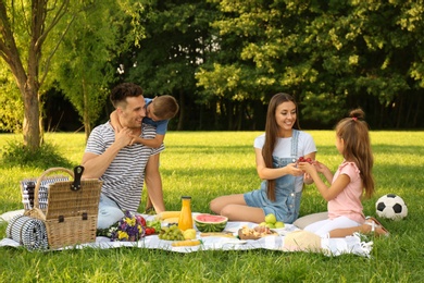 Photo of Happy family having picnic in park on sunny summer day