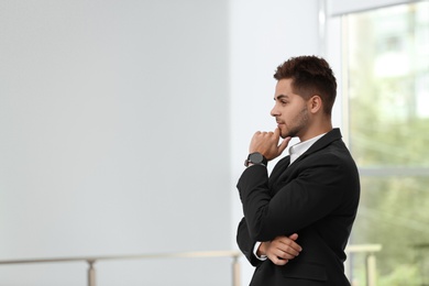 Photo of Portrait of handsome young man in elegant suit indoors. Space for text