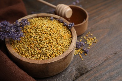 Photo of Fresh bee pollen granules and lavender on wooden table, closeup. Space for text