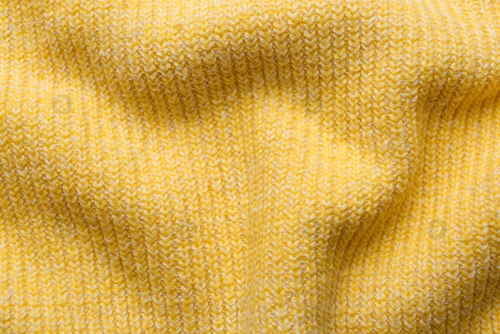 Photo of Yellow knitted fabric as background, top view