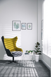 Photo of Comfortable armchair near white wall in light room