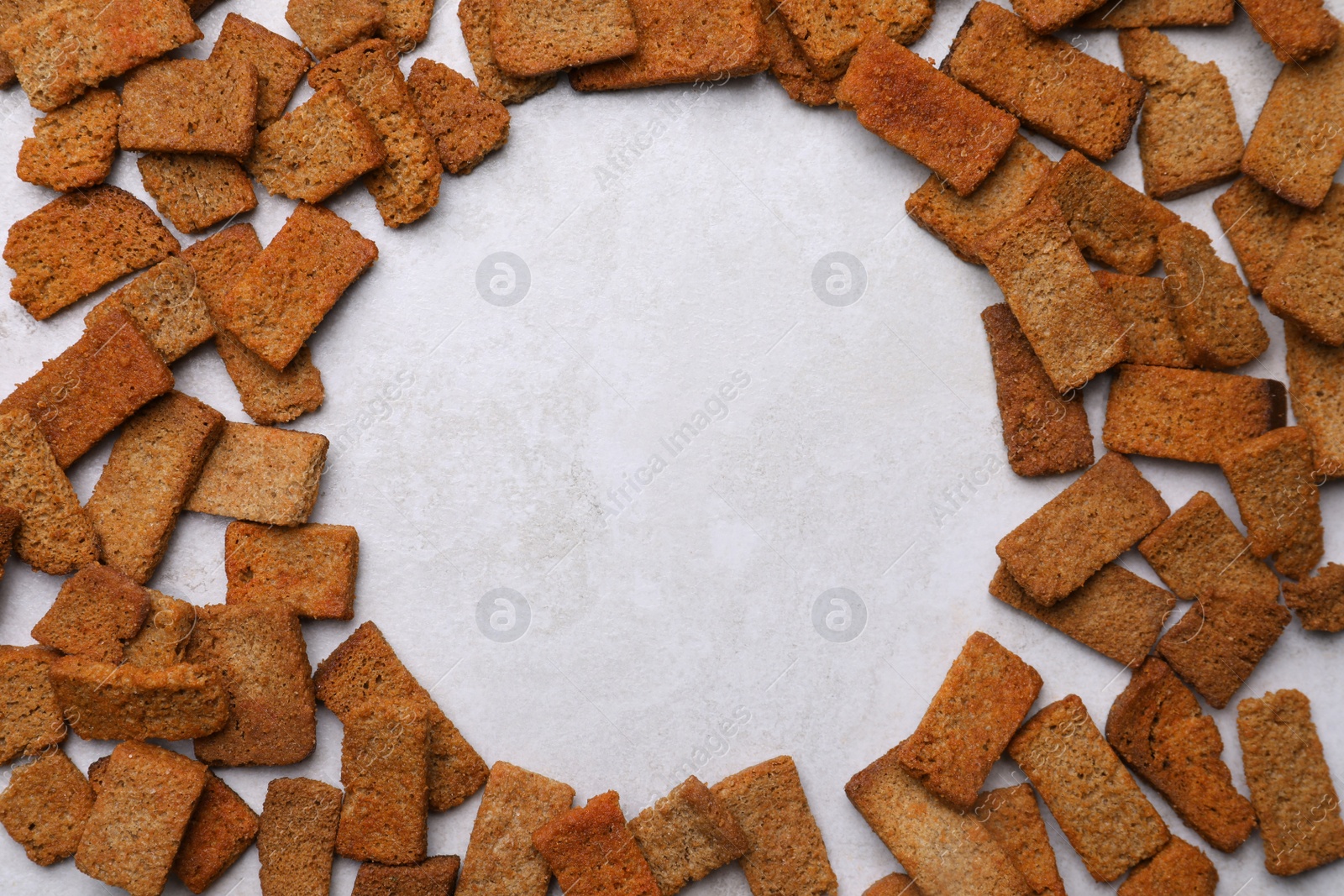 Photo of Frame of crispy rusks on light table, flat lay. Space for text