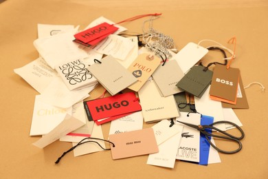 Leiden, Netherlands - December 6, 2023: Different clothing tags and scissors on kraft paper sheet