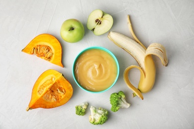 Photo of Flat lay composition with bowl of healthy baby food on gray background