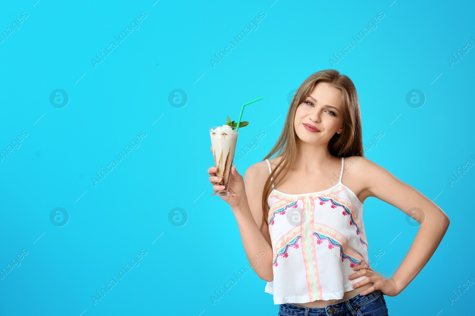 Photo of Young woman with glass of delicious milk shake on color background