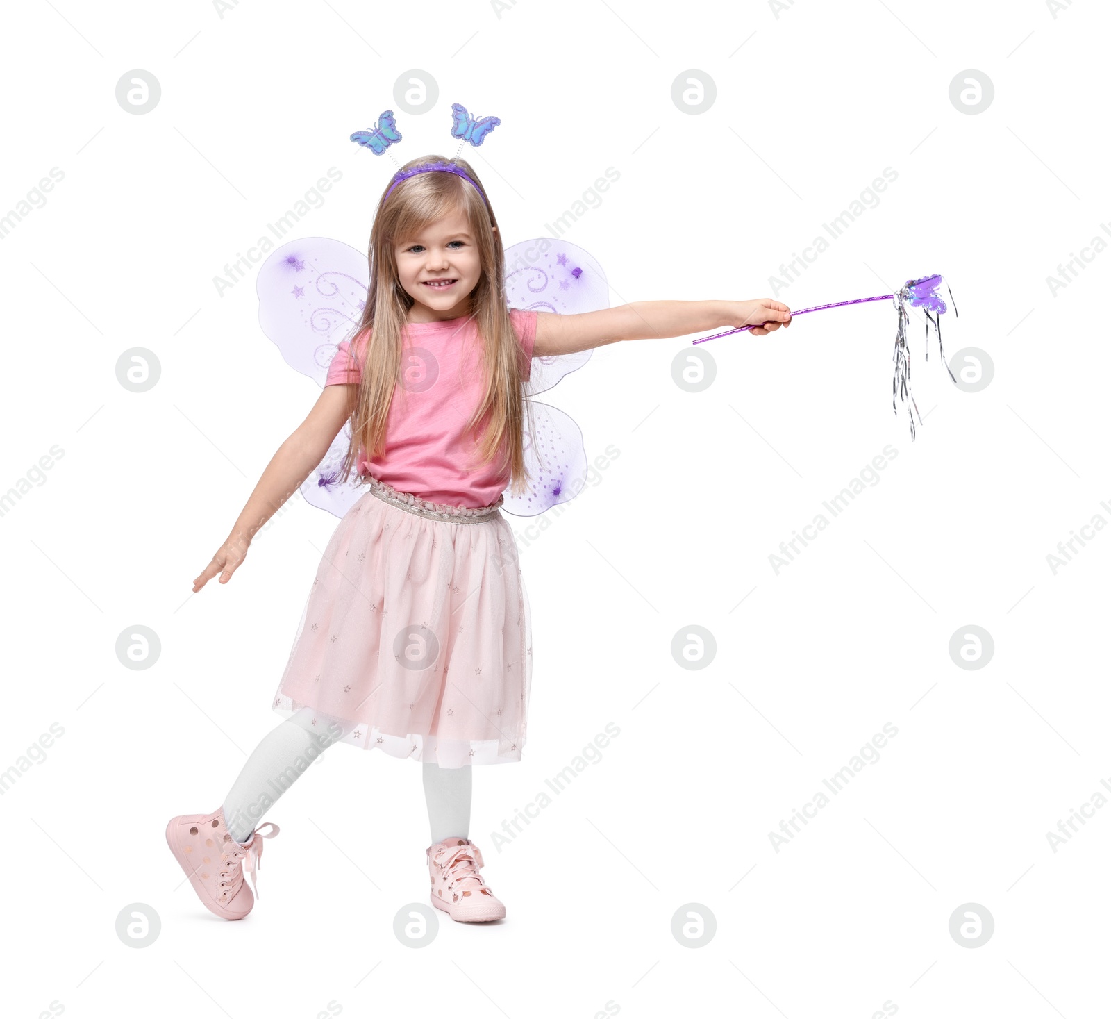 Photo of Cute little girl in fairy costume with violet wings and magic wand on white background