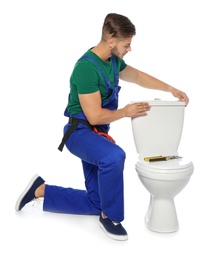 Young man working with toilet tank, isolated on white