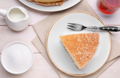 Piece of tasty sponge cake served on white wooden table, flat lay