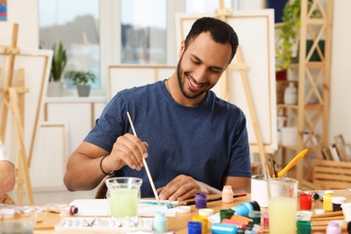 Photo of Young man painting in studio. Creative hobby