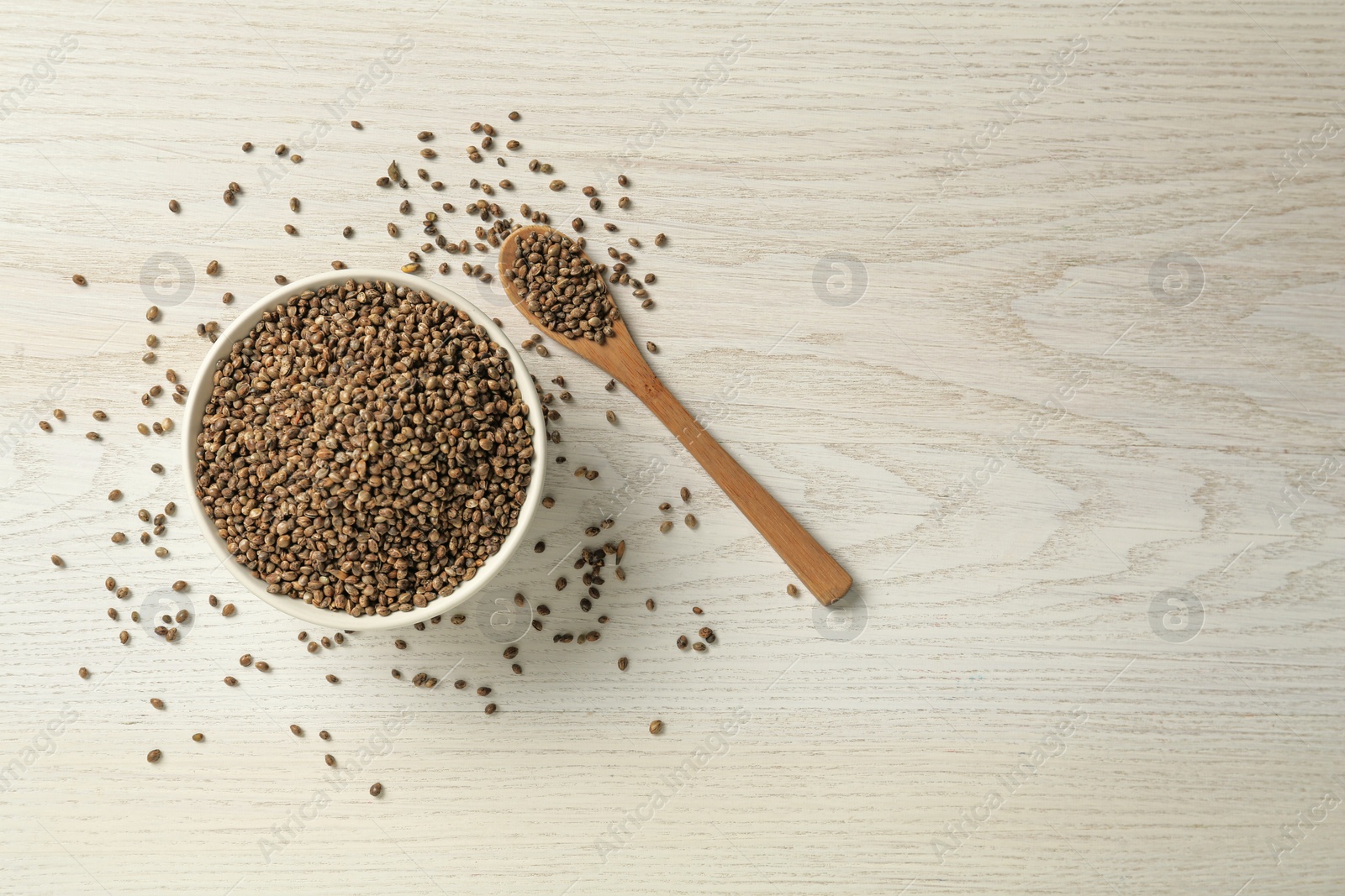 Photo of Ceramic bowl with chia seeds on light wooden table, flat lay and space for text. Cooking utensils