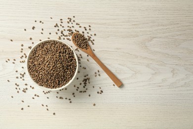 Photo of Ceramic bowl with chia seeds on light wooden table, flat lay and space for text. Cooking utensils