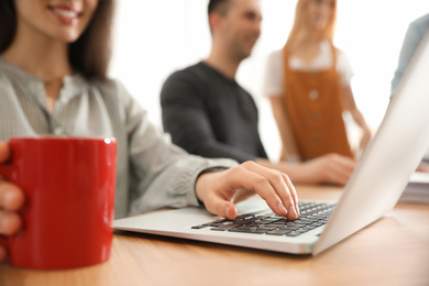 Female designer working with laptop at table, closeup