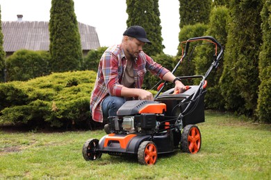 Photo of Man with modern lawn mower in garden