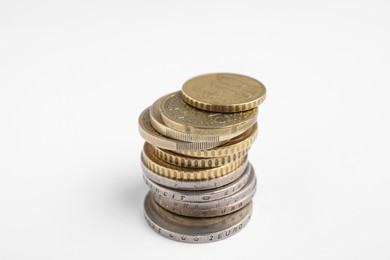 Many Euro coins stacked on white background, closeup