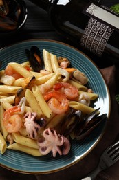 Delicious pasta with seafood served on black table, flat lay