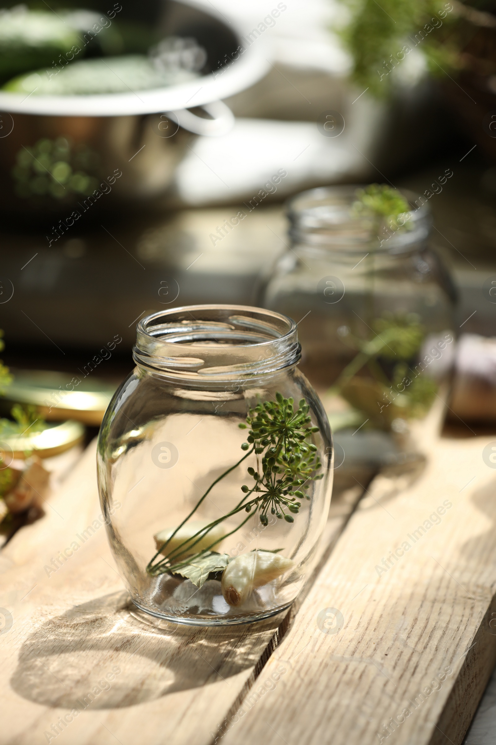 Photo of Empty glass jar and ingredients prepared for canning on wooden table