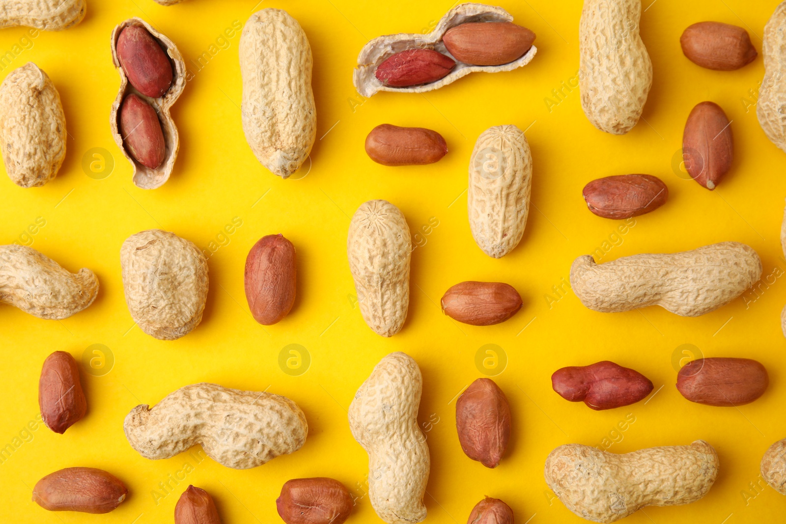 Photo of Fresh peanuts on yellow table, flat lay