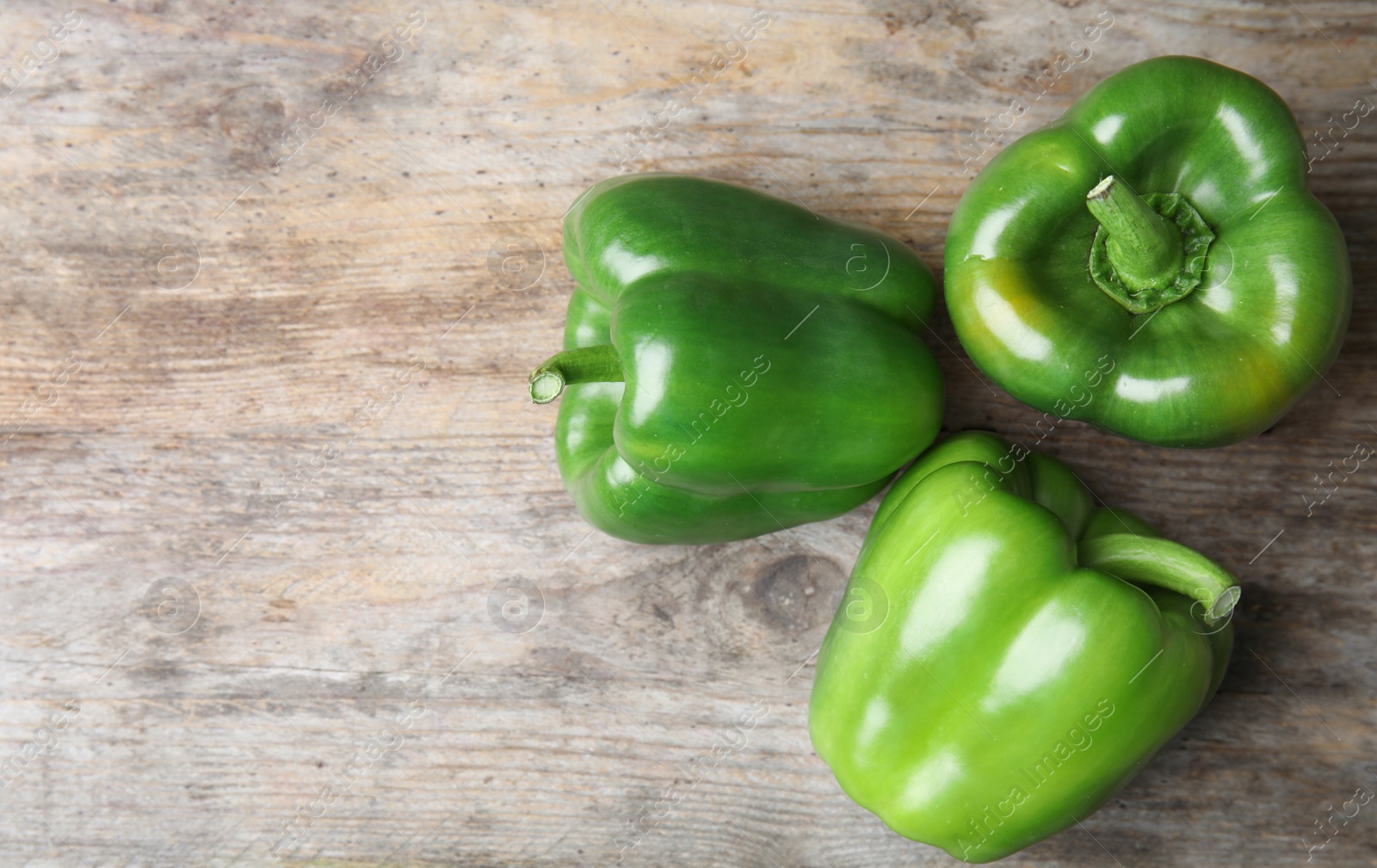 Photo of Raw ripe paprika peppers on wooden background, top view