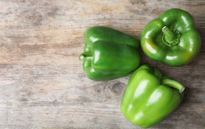 Photo of Raw ripe paprika peppers on wooden background, top view