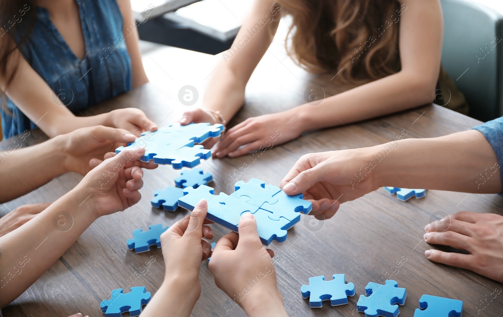 Photo of People with puzzle, closeup of hands. Unity concept