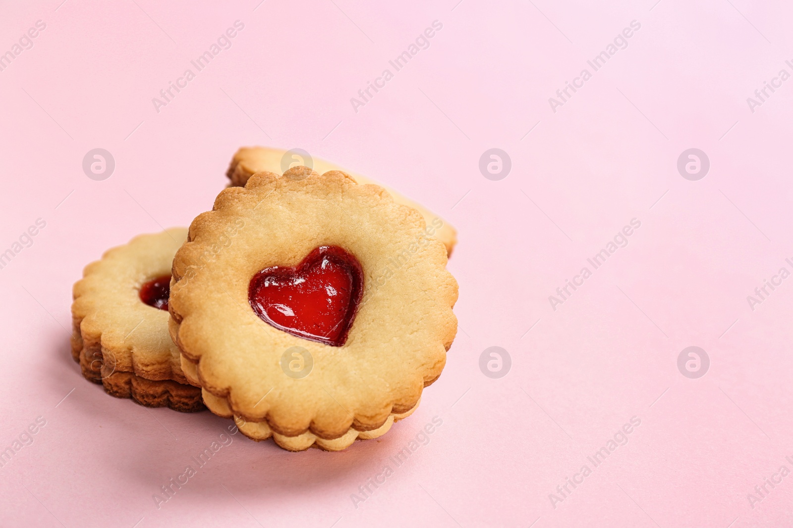 Photo of Traditional Christmas Linzer cookies with sweet jam on color background