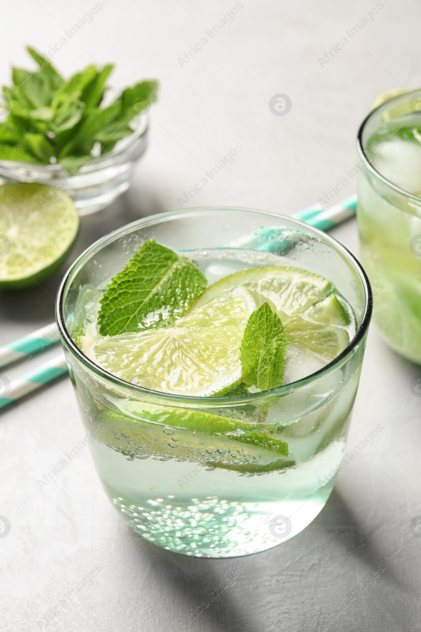 Photo of Refreshing beverage with mint and lime in glass on table