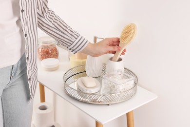 Photo of Bath accessories. Woman with brush indoors, closeup