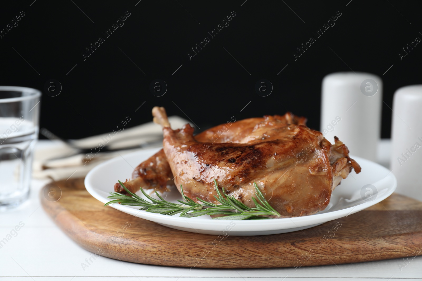 Photo of Tasty cooked rabbit meat with rosemary on table, closeup