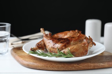 Tasty cooked rabbit meat with rosemary on table, closeup