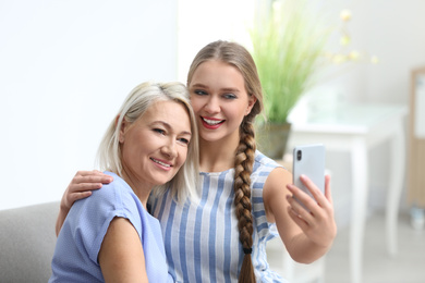 Photo of Happy mother and daughter taking selfie at home