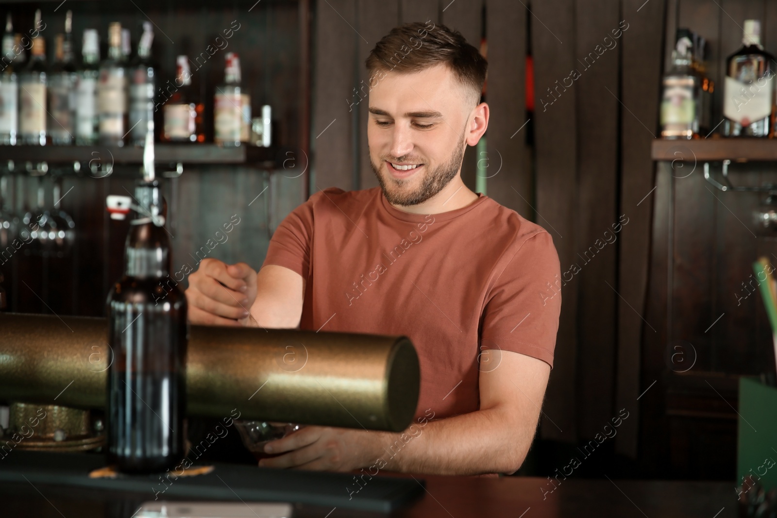 Photo of Bartender working at beer tap in pub