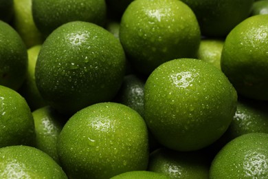 Photo of Fresh ripe limes with water drops as background, closeup