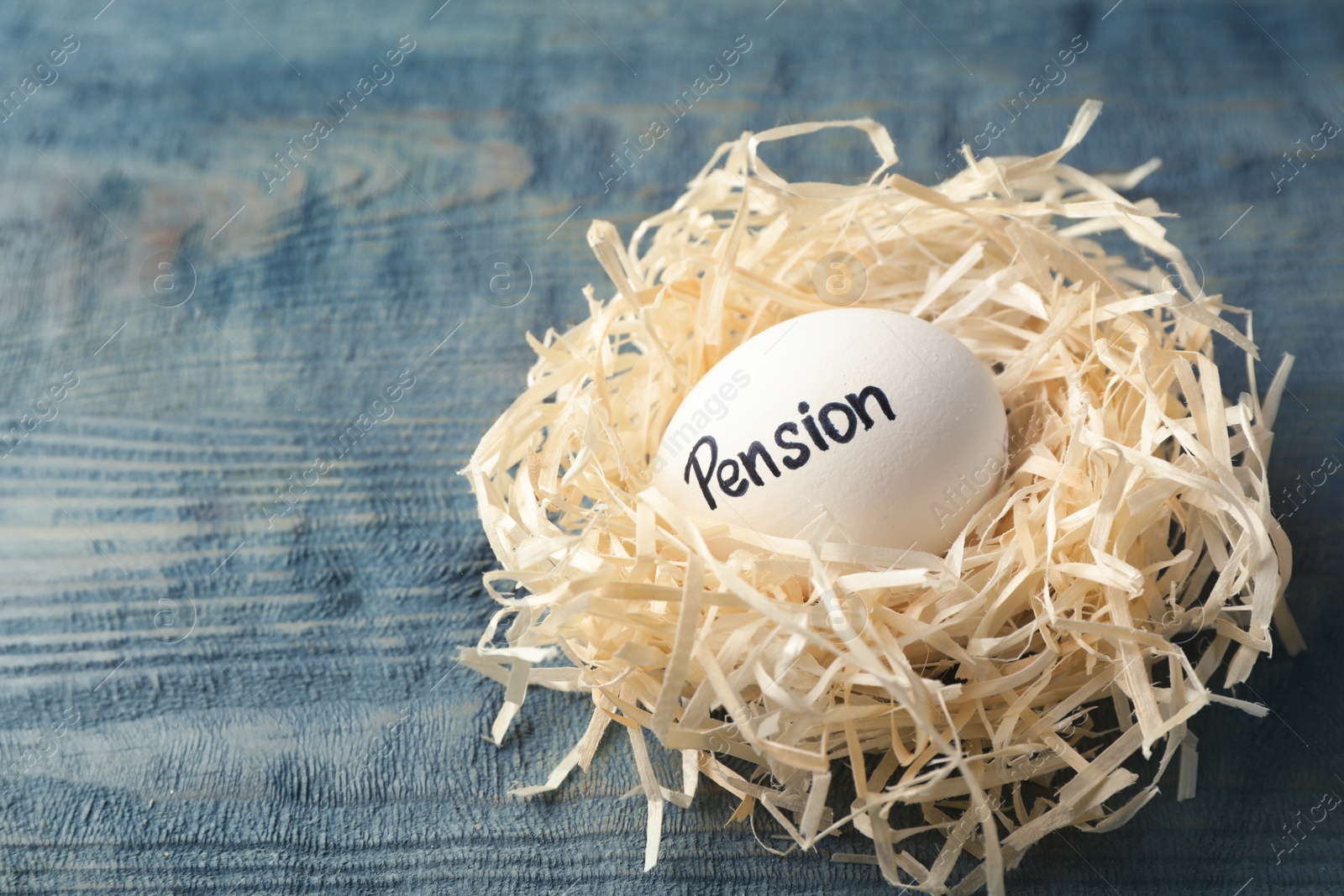 Photo of Egg with word PENSION in nest on wooden background. Space for text