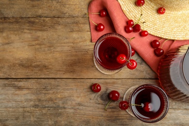 Photo of Delicious cherry wine with ripe juicy berries on wooden table, flat lay. Space for text