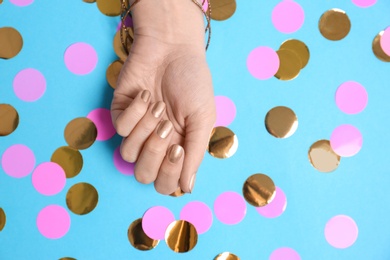 Photo of Woman showing golden manicure on color background, top view with space for text. Nail polish trends