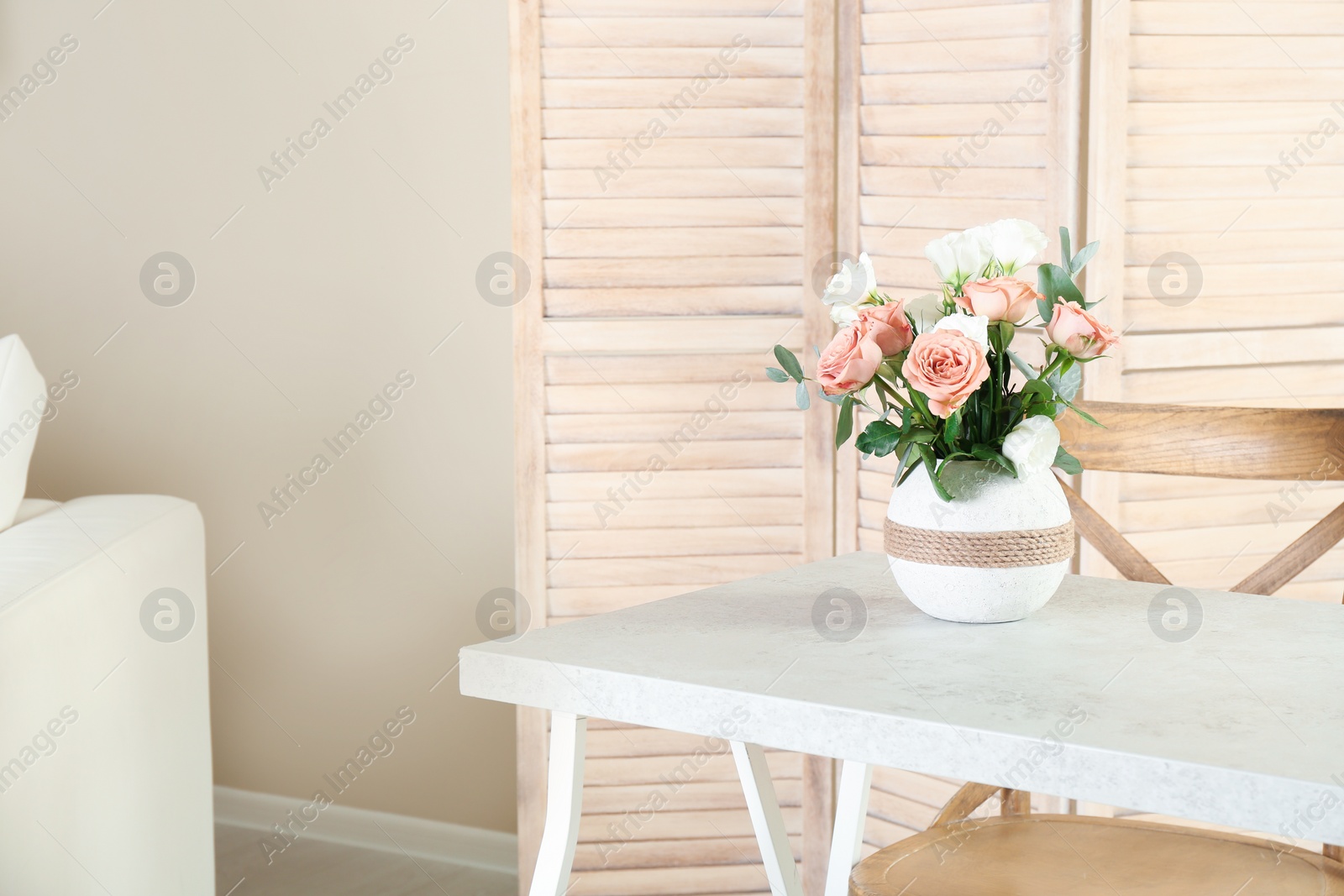 Photo of Vase with beautiful flowers as element of interior design on table in room. Space for text