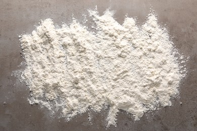 Scattered flour on grey textured table, top view