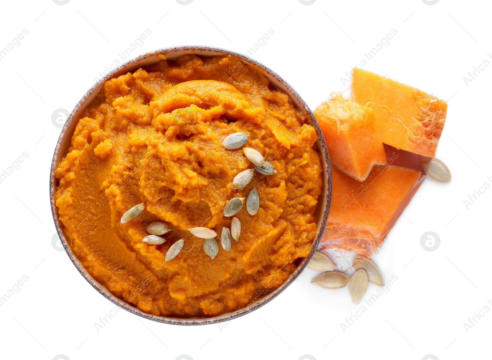 Photo of Delicious vegetable puree with pumpkin pieces and seeds on white background, top view. Healthy food