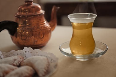 Glass cup of aromatic tea on table