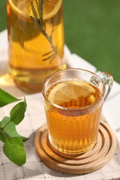 Glass cup of tasty iced tea with lemon on table, closeup