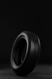 Photo of New car tire on black background