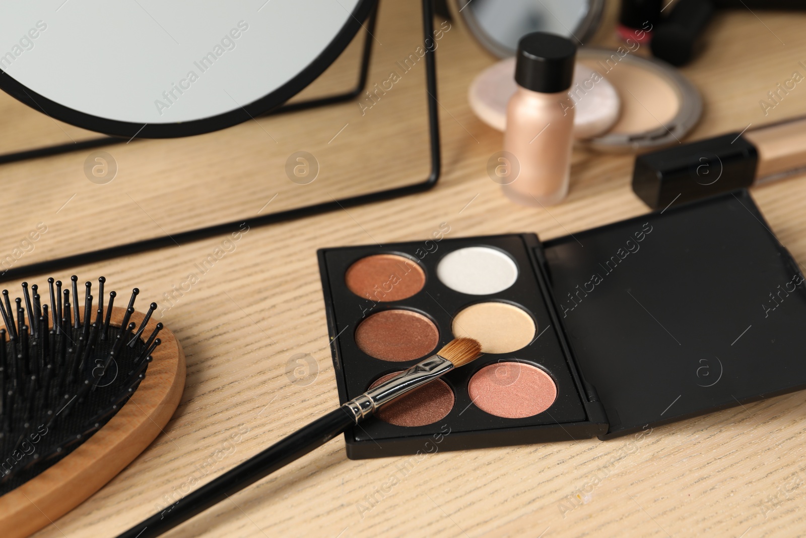 Photo of Eyeshadows and makeup brush on dressing table, closeup